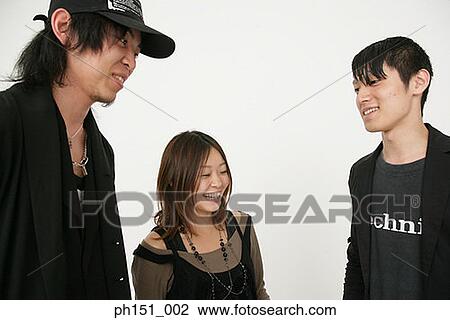 Close-up of a young woman and two young men smiling View Large Photo Image Stock Image - Close-up of a young woman and two young men smiling. Fotosearch