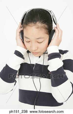 Close-up of a young woman listening to music with her eyes closed View Large Photo Image Stock Photo - Close-up of a young woman listening to music with her eyes closed. Fotosearch