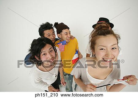 Stock Image - High angle view of a young woman smiling with four young men. Fotosearch