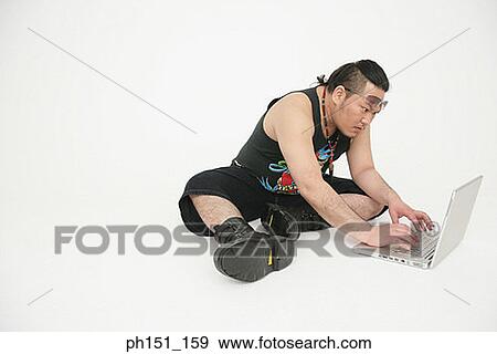 Mid adult man using a laptop View Large Photo Image Stock Photo - Mid adult man using a laptop. Fotosearch