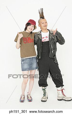 Stock Image - Portrait of a young couple showing a thumbs up sign. Fotosearch