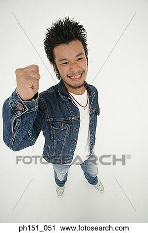 Portrait of a young man clenching his fist and smiling View Large Photo Image Stock Image - Portrait of a young man clenching his fist and smiling. Fotosearch