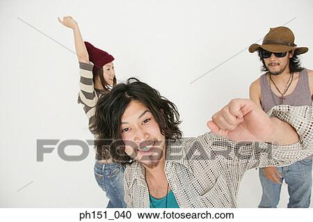 Stock Image - Portrait of a young man dancing with his friends and looking cheerful. Fotosearch