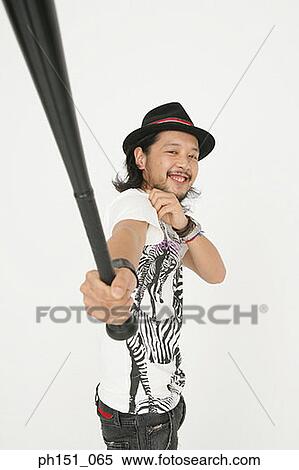 Stock Photography - Portrait of a young man holding a baseball bat and smiling. Fotosearch