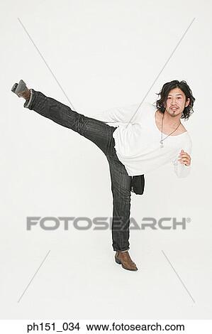 Portrait of a young man kicking and smiling View Large Photo Image Picture - Portrait of a young man kicking and smiling. Fotosearch