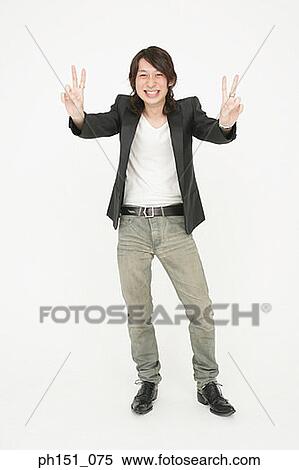 Portrait of a young man making a peace sign and looking cheerful View Large Photo Image Stock Photography - Portrait of a young man making a peace sign and looking cheerful. Fotosearch
