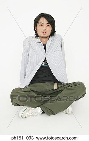 Stock Image - Portrait of a young man sitting on the floor and thinking. Fotosearch