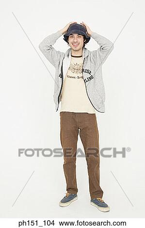 Portrait of a young man smiling with his hands on his head View Large Photo Image Picture - Portrait of a young man smiling with his hands on his head. Fotosearch