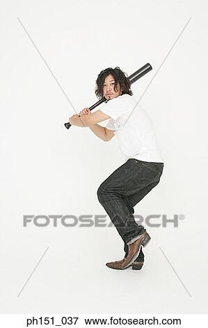 Portrait of a young man swinging a baseball bat View Large Photo Image Stock Photo - Portrait of a young man swinging a baseball bat. Fotosearch
