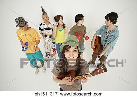 Portrait of a young woman and her friends playing musical instruments View Large Photo Image Stock Photo - Portrait of a young woman and her friends playing musical instruments. Fotosearch