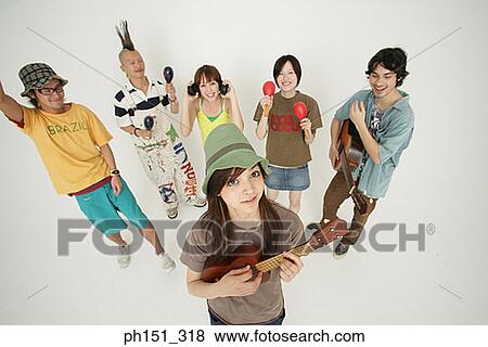 Portrait of a young woman and her friends playing musical instruments View Large Photo Image Stock Photo - Portrait of a young woman and her friends playing musical instruments. Fotosearch