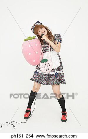 Portrait of a young woman holding a microphone and a cushion View Large Photo Image Picture - Portrait of a young woman holding a microphone and a cushion. Fotosearch