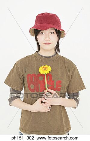 Portrait of a young woman holding a flower View Large Photo Image Stock Image - Portrait of a young woman holding a flower. Fotosearch