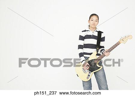 Stock Photo - Portrait of a young woman playing the guitar. Fotosearch