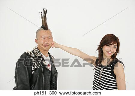 Portrait of a young woman punching a young man on his cheek View Large Photo Image Stock Image - Portrait of a young woman punching a young man on his cheek. Fotosearch