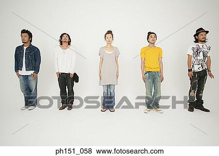 Stock Photo - Portrait of a young woman standing between four young men and posing. Fotosearch