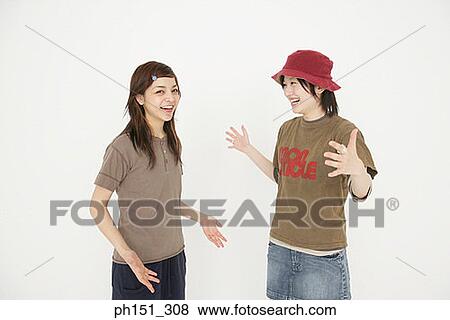 Portrait of a young woman talking with her friend and laughing View Large Photo Image Stock Photo - Portrait of a young woman talking with her friend and laughing. Fotosearch