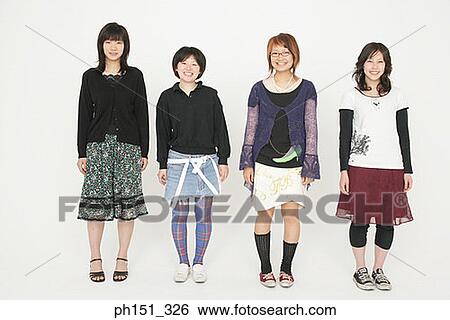 Stock Photograph - Portrait of four young women standing and smiling. Fotosearch