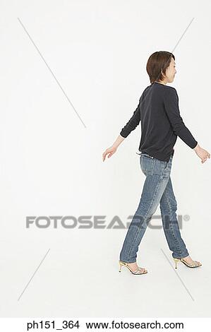 Picture - Rear view of a young woman walking. Fotosearch