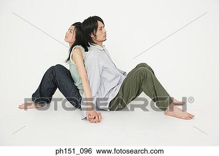 Side profile of a young couple sitting back to back View Large Photo Image Stock Photograph - Side profile of a young couple sitting back to back. Fotosearch