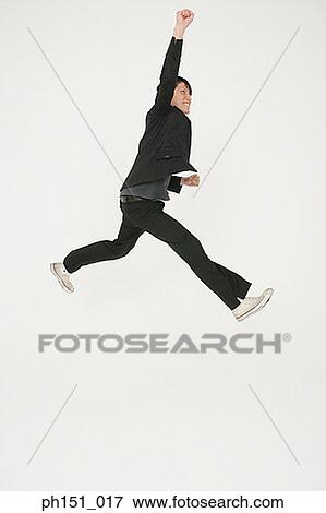 Side profile of a young man jumping with joy View Large Photo Image Stock Photo - Side profile of a young man jumping with joy. Fotosearch