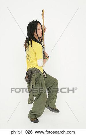 Side profile of a young man playing the guitar View Large Photo Image Stock Photograph - Side profile of a young man playing the guitar. Fotosearch