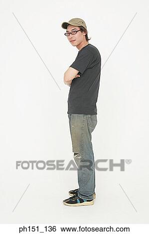 Side profile of a young man standing with his arms crossed View Large Photo Image Stock Photograph - Side profile of a young man standing with his arms crossed. Fotosearch