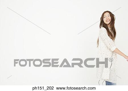 Side profile of a young woman listening to music on headphones View Large Photo Image Stock Image - Side profile of a young woman listening to music on headphones. Fotosearch