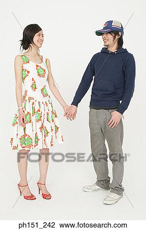 Young couple standing and holding hands View Large Photo Image Stock Image - Young couple standing and holding hands. Fotosearch