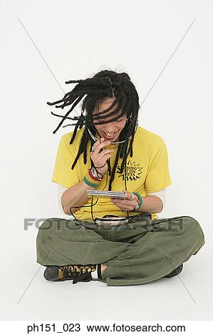 Stock Image - Young man listening to music and smiling. Fotosearch