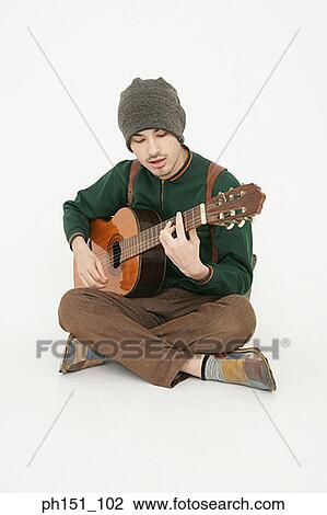 Stock Image - Young man playing the guitar. Fotosearch