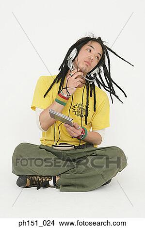 Young man wearing headphones and listening to music View Large Photo Image Picture - Young man wearing headphones and listening to music. Fotosearch