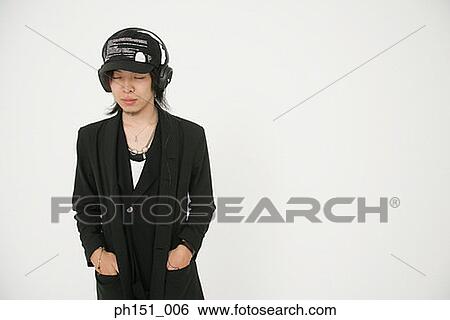 Young man wearing headphones and listening to music View Large Photo Image Stock Photograph - Young man wearing headphones and listening to music. Fotosearch