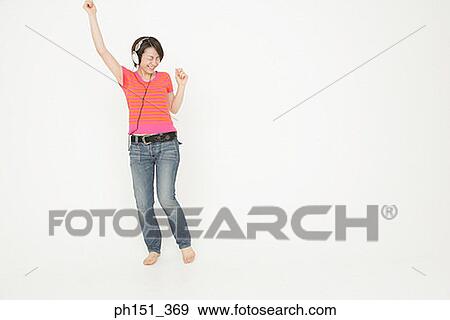 Stock Photo - Young woman dancing and listening to music. Fotosearch