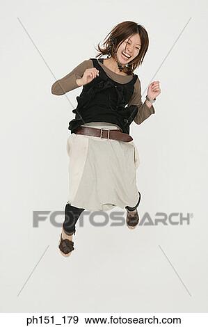 Stock Photo - Young woman jumping and laughing. Fotosearch
