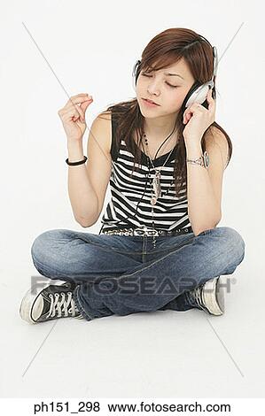 Young woman listening to music and snapping her fingers View Large Photo Image Stock Photo - Young woman listening to music and snapping her fingers. Fotosearch