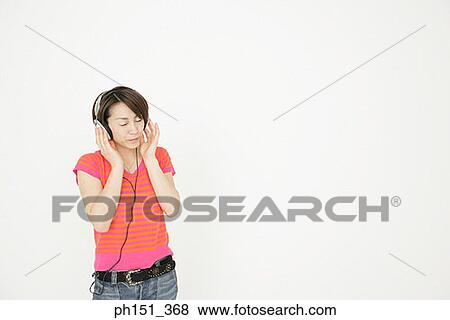 Stock Photo - Young woman listening to music. Fotosearch