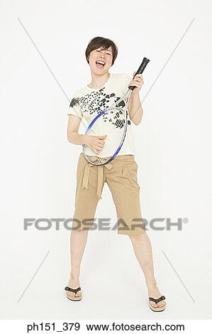 Young woman playing an air guitar with a tennis racket and singing View Large Photo Image Stock Photo - Young woman playing an air guitar with a tennis racket and singing. Fotosearch