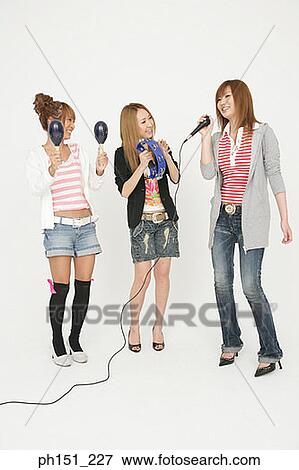 Young woman singing with another two young women playing musical instruments View Large Photo Image Stock Photo - Young woman singing with another two young women playing musical instruments. Fotosearch