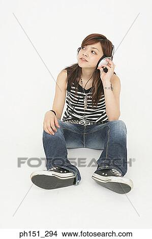 Young woman sitting on the floor and listening to music View Large Photo Image Picture - Young woman sitting on the floor and listening to music. Fotosearch