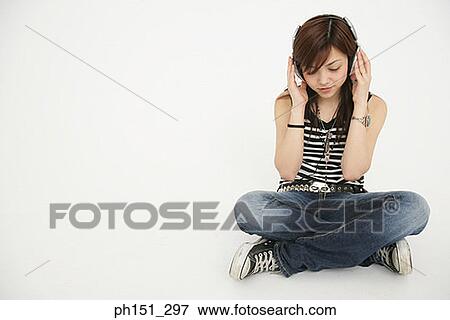 Young woman sitting on the floor and listening to music View Large Photo Image Stock Photo - Young woman sitting on the floor and listening to music. Fotosearch