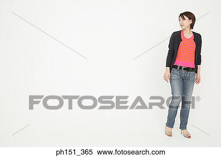 Young woman standing and looking sideways View Large Photo Image Stock Photography - Young woman standing and looking sideways. Fotosearch