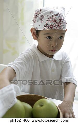 Close-up of a boy standing near a bowl of green apples View Large Photo Image Stock Image - Close-up of a boy standing near a bowl of green apples. Fotosearch