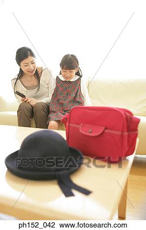 Close-up of a fedora hat and a schoolbag on the table with a mid adult woman and her daughter in the background View Large Photo Image Stock Image - Close-up of a fedora hat and a schoolbag on the table with a mid adult woman and her daughter in the background. Fotosearch