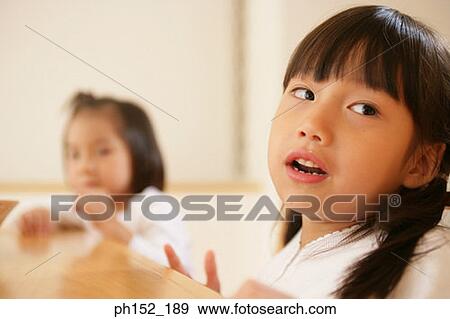 Close-up of a girl and her sister View Large Photo Image Stock Photo - Close-up of a girl and her sister. Fotosearch