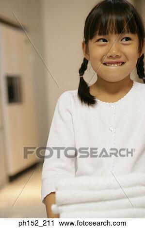 Close-up of a girl carrying a stack of folded towels View Large Photo Image Stock Image - Close-up of a girl carrying a stack of folded towels. Fotosearch