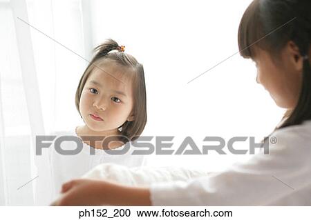 Close-up of a girl looking at her sister View Large Photo Image Stock Image - Close-up of a girl looking at her sister. Fotosearch