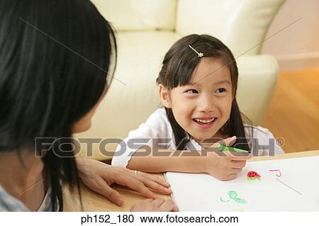 Close-up of a girl sitting with her mother and drawing View Large Photo Image Stock Image - Close-up of a girl sitting with her mother and drawing. Fotosearch