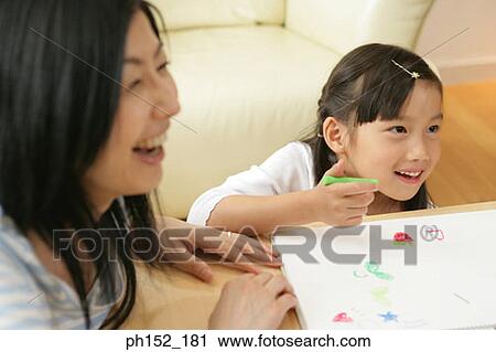 Close-up of a girl sitting with her mother and drawing View Large Photo Image Stock Image - Close-up of a girl sitting with her mother and drawing. Fotosearch