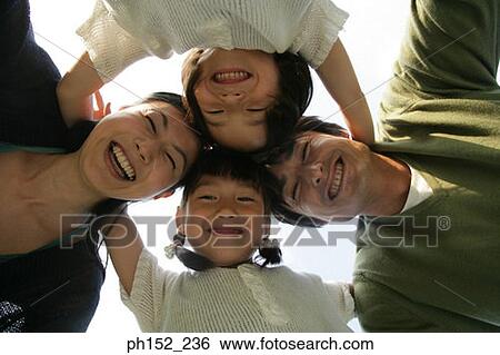 Close-up of a mid adult couple and their two daughters forming a circle View Large Photo Image Stock Photograph - Close-up of a mid adult couple and their two daughters forming a circle. Fotosearch